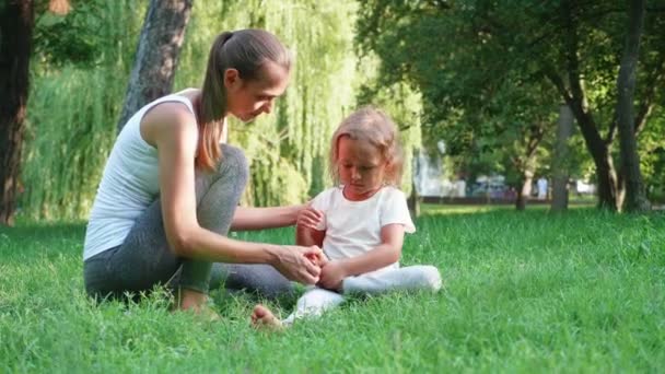 年轻的运动母亲教练她的小可爱的女儿做瑜伽练习 — 图库视频影像
