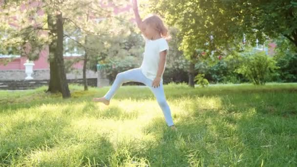 Barnet lär sig akrobatik på parken i slow motion — Stockvideo