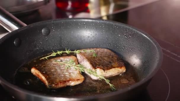 油炸鱼, 两片 loban 鱼片在热气腾腾的煎锅上. — 图库视频影像