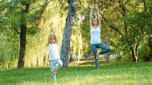 Anya és a kis aranyos lánya jóga gyakorlása együtt — Stock Fotó