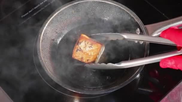 Gebratener Fisch, das Thunfischfilet auf der dampfenden Pfanne in Zeitlupe. — Stockvideo