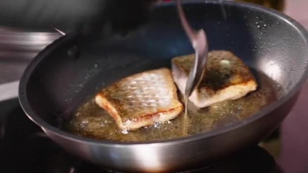 Peixe frito, dois pedaços de filé de lóbulo na frigideira . — Vídeo de Stock