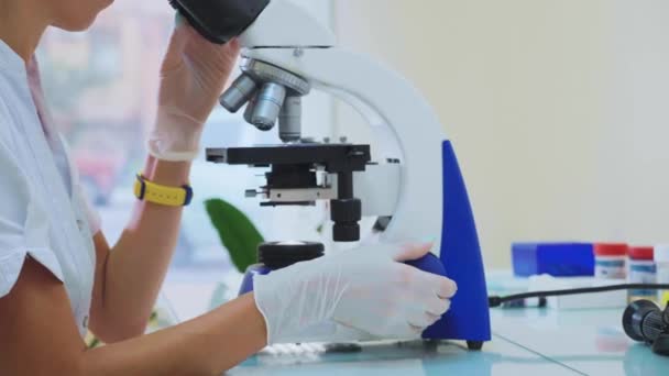 Trabajador veterinario que utiliza microscopio para analizar muestras de sangre de animales — Vídeo de stock
