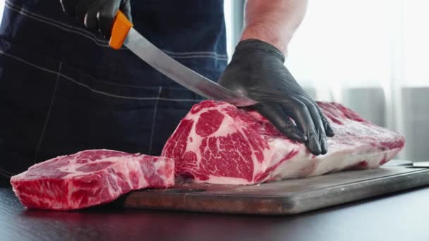 Chef coupe de la viande crue sur le panneau de bois avec le couteau, gros plan — Video