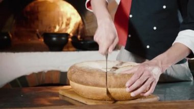 Ticari mutfak Şef kesme ekmek arka planda şömineli