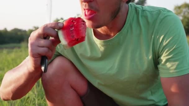 Boer eet watermeloen op het gebied van de biologische boerderij. — Stockvideo