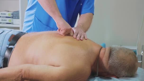 The physiotherapist performs therapeutic procedures with an elderly patient — Stock Video
