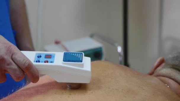 Senior mannelijke patiënt ontvangen elektrostatische therapie procedure op zijn rug. — Stockvideo