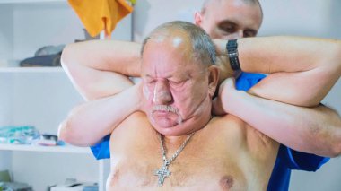 Fizyoterapist tedavi prosedürlerinin bir yaşlı hasta ile gerçekleştirir.