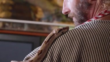 Yılan sakallı hippi omuzlarında kaynıyor