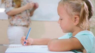 Küçük şirin kız öğretmen egzersiz kitap ile sınıf ve çalışmalar oturur