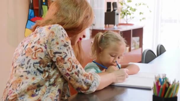 Küçük şirin kız öğretmen egzersiz kitap ile sınıf ve çalışmalar oturur — Stok video