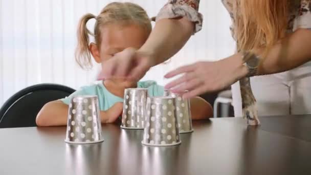 Küçük kız çocuk cups ile kabuk oyun sırasında test psikolog — Stok video