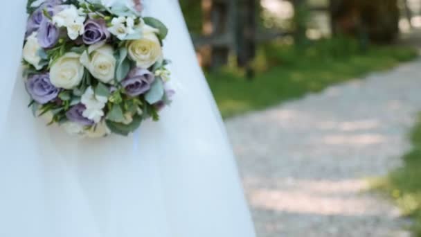 Bouquet de fleurs de mariée. Mariée marche et tient un bouquet dans la main . — Video