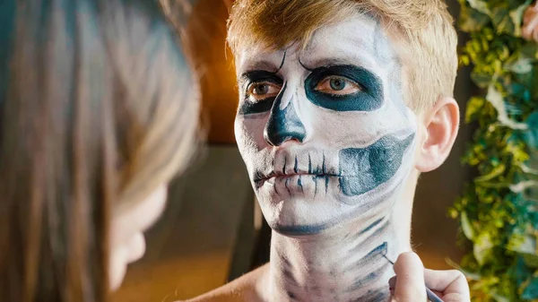 Make-up artist makes the guy halloween make up. Halloween male face art.