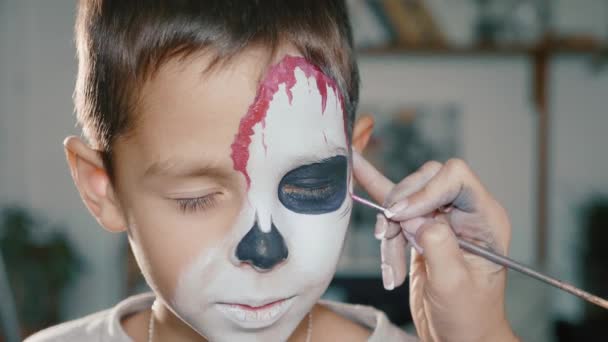 Sminkes teszi a fiú halloween teszik ki. Halloween gyermek arc art. — Stock videók