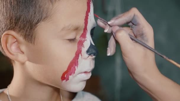 Maquillaje artista hace que el niño halloween maquillaje. Halloween niño cara arte . — Vídeos de Stock