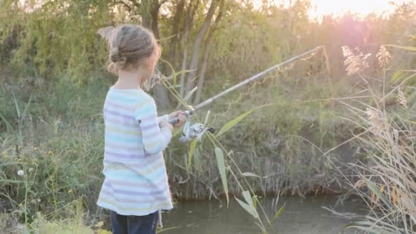 Ragazza caucasica pesca sul laghetto, vista posteriore — Video Stock