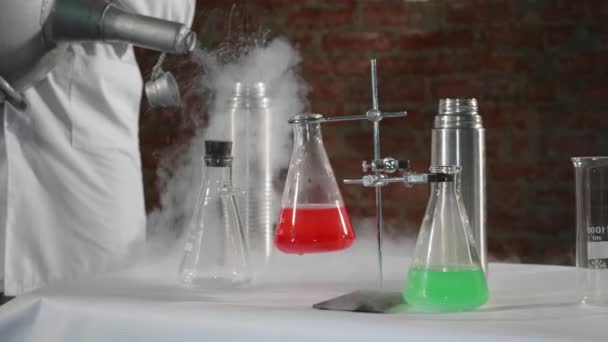 Ученый заливает жидкий азот в стальную термос-бутылку в лаборатории — стоковое видео