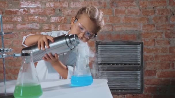 Lindo niño investigador está llevando a cabo un experimento con nitrógeno líquido — Vídeo de stock