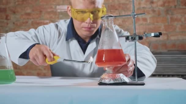 Учёный проводит эксперимент, и его рука загорается — стоковое видео