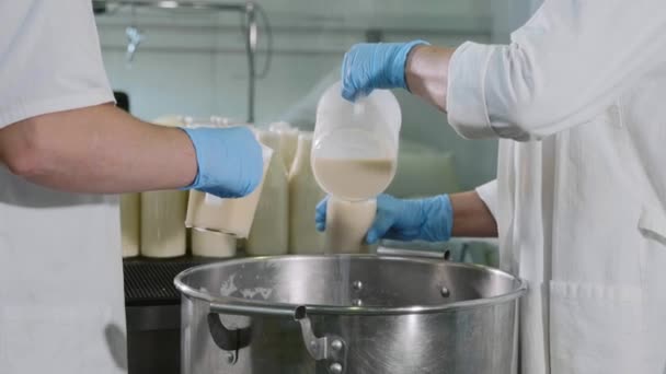 Werknemers een melk in flessen vullen door handen in melk fabriek — Stockvideo
