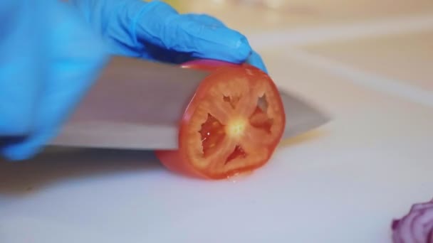 Häuptlinge Hände in Handschuhen schneidet Tomate, Nahaufnahme — Stockvideo