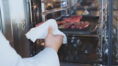 Cook fast food restoran fırında beşamel sos ve sosis ile fırın tepsisine koyun