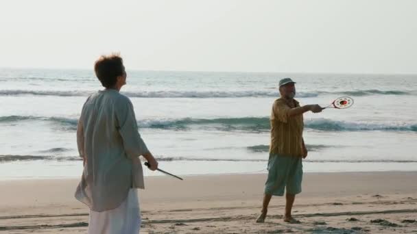 Ανώτερος ζευγάρι παίζει μπάλα ballon tai chi στην παραλία σε αργή κίνηση. — Αρχείο Βίντεο