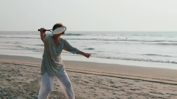Coppia senior attiva che gioca a pallone tai chi in spiaggia al rallentatore . — Video Stock