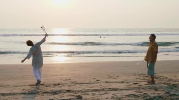 Ativo casal sênior jogando tai chi bola de balão na praia em câmera lenta . — Vídeo de Stock