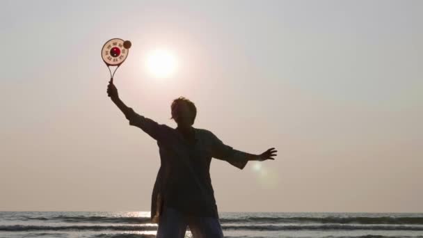 Mujer mayor practicando tai chi globo en la playa al atardecer — Vídeos de Stock