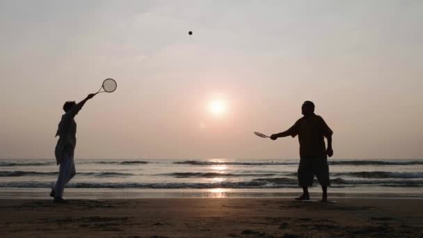 Aktivní senior pár hrát míč ballon tai chi na pláži v pomalém pohybu. — Stock video