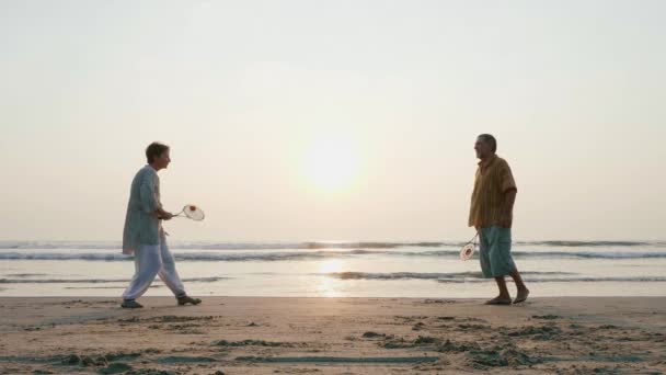 Aktivní senior pár hrát míč ballon tai chi na pláži v pomalém pohybu. — Stock video