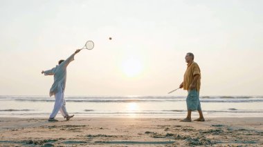 Tai chi ballon top kumsalda oynarken etkin üst düzey çift.