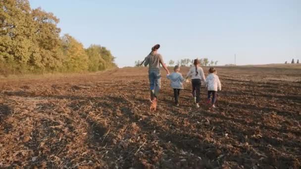 Фермер со своими четырьмя детьми отправляется на фермерское поле для совместной работы — стоковое видео