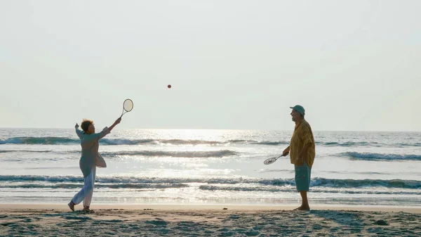 Pareja mayor activa jugando tai chi ballon ball en la playa . — Foto de Stock