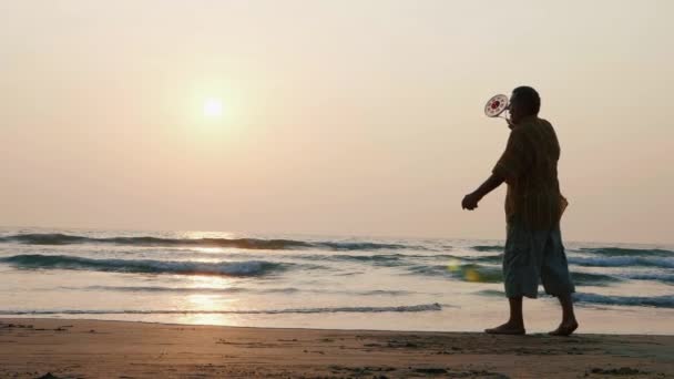 Coppia senior attiva che gioca a pallone tai chi in spiaggia al rallentatore . — Video Stock