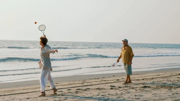 Pareja mayor activa jugando tai chi ballon ball en la playa . — Foto de Stock