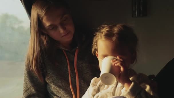 Young mother with little daughter travelling on indian train together — Stock Video