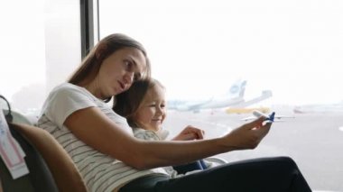 Anne ve kızı ile oynayan uçağın Havaalanı terminal içinde birlikte oyuncak