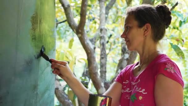 Vrouw schilderij schoolbord in zwarte kleur voor vernieuwen het openlucht school — Stockvideo