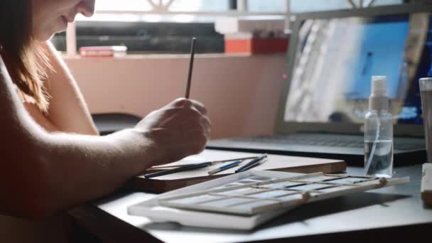 Tânăra femeie trece o lecție în pictura acuarelă online la domiciliu — Videoclip de stoc