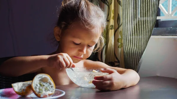 The child is having breakfast. Portrait of little cute girl eats porridge. — Stock Photo, Image