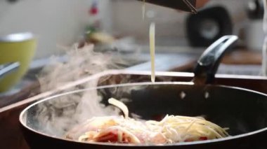 Cook tavada, kırmızı domates soslu spagetti üzerinde peynir losyonları yakın çekim.