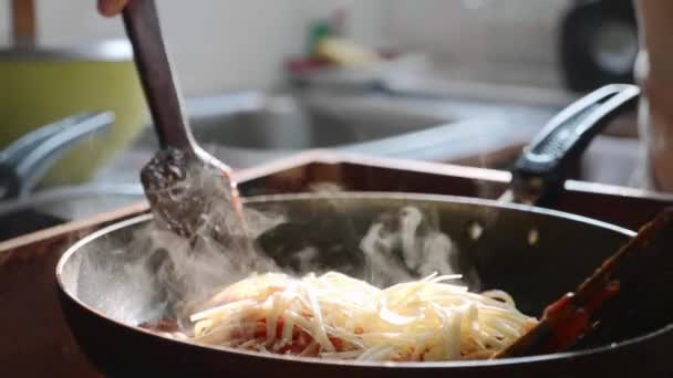 Cooking and stirring the spaghetti with red tomato sauce in the frying pan. — Stock Video