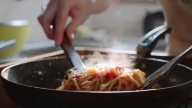 Pişirme ve kızartma tavada karıştırarak kırmızı domates soslu spagetti.