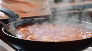 Pişirme ve kızartma tava, yakın çekim üzerinde spagetti domates sosu karıştırarak