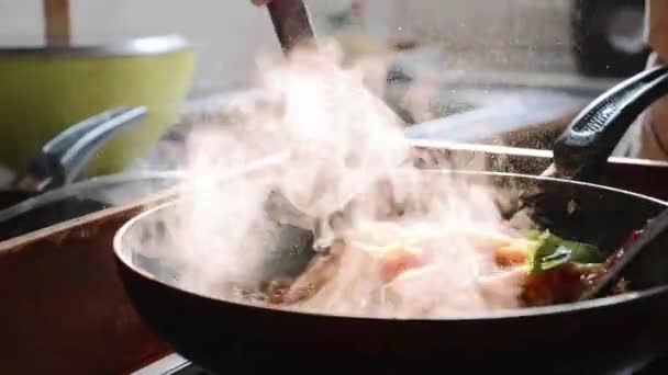 Μαγείρεμα και ανακατεύοντας τα μακαρόνια με κόκκινη σάλτσα στο τηγάνι. — Αρχείο Βίντεο