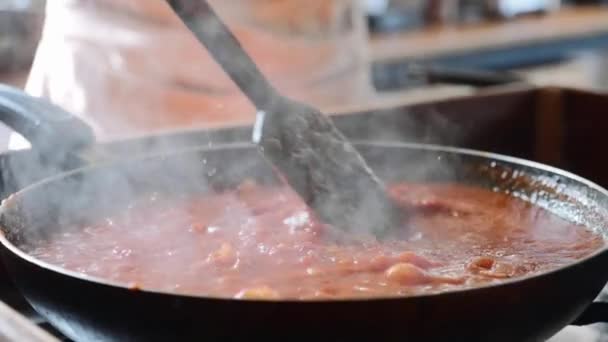 Cocinar y revolver la salsa de tomate para espaguetis en la sartén, de cerca — Vídeos de Stock